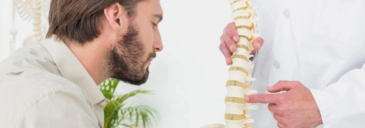 Chiropractic Arlington TX Man Looking At Spinal Disc Model Chiropractic Arlington TX Man Looking At Spinal Disc Model